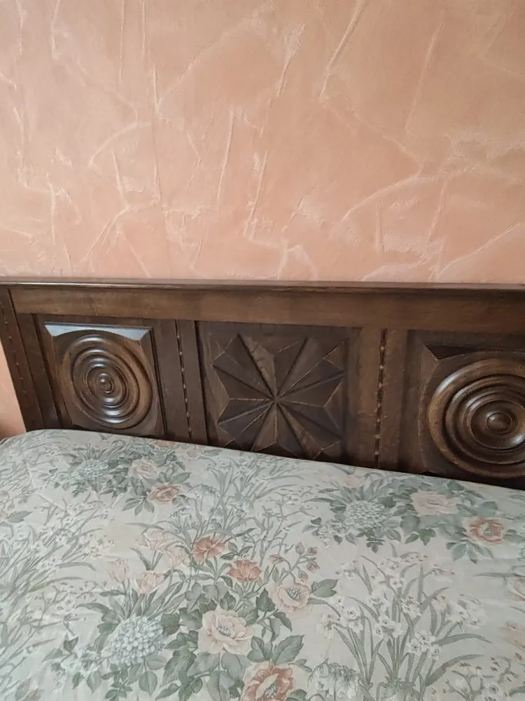 Lit ancien sculpté dans une maison de famille à vider
